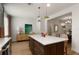 Modern kitchen island with white countertop, custom cabinetry and three wood chairs at 2036 Brink Aly, Orlando, FL 32814