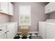 Well-lit laundry room featuring white cabinets, a checkerboard floor, and modern washer and dryer at 2036 Brink Aly, Orlando, FL 32814