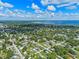 High-definition aerial of a neighborhood with a highlighted pink marker, showcasing homes amid trees and green lawns at 205 9Th St, St Cloud, FL 34769