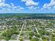 Overhead view of a residential area with a prominent location marker over a home amidst green lawns and trees at 205 9Th St, St Cloud, FL 34769