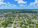 Scenic aerial view of a suburban community with diverse housing styles, green spaces, and clear blue skies at 205 9Th St, St Cloud, FL 34769