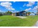 Blue house with a large lawn, carport, and wooden fence on a sunny day at 205 9Th St, St Cloud, FL 34769