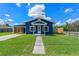 Inviting blue home featuring a well-manicured lawn and cozy covered front porch at 205 9Th St, St Cloud, FL 34769
