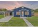 Charming blue home with a carport, inviting entrance, and green lawn at 205 9Th St, St Cloud, FL 34769