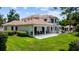 Exterior shot of the backyard featuring a spacious patio and lush green lawn of a beautiful estate home at 2211 Azalea Pl, Winter Park, FL 32789