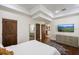 Cozy bedroom with a plush bed, mounted TV, and dark wood floors with a patterned rug at 2211 Azalea Pl, Winter Park, FL 32789