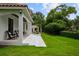 Expansive backyard featuring a covered patio, lush lawn, and landscaped garden at 2211 Azalea Pl, Winter Park, FL 32789