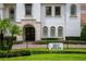 Stately home featuring detailed stone accents, lush landscaping, and a secure gated entrance, exuding curb appeal at 2211 Azalea Pl, Winter Park, FL 32789