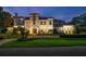 Stately two-story home featuring a meticulously manicured lawn, gated entrance, and an inviting facade at twilight at 2211 Azalea Pl, Winter Park, FL 32789