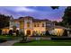 Elegant two-story home showcasing meticulous landscaping, iron gate, and distinctive Mediterranean-style architecture at 2211 Azalea Pl, Winter Park, FL 32789