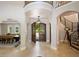 Elegant foyer with travertine floors, arched doorways, grand staircase, and decorative chandelier at 2211 Azalea Pl, Winter Park, FL 32789
