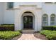 Elegant entryway with arched doorway, custom wrought iron doors, and professionally landscaped surroundings at 2211 Azalea Pl, Winter Park, FL 32789