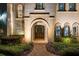 Elegant front entrance with stone archway, double doors, and manicured landscaping providing an inviting curb appeal at 2211 Azalea Pl, Winter Park, FL 32789
