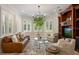 Elegant living room with large windows, a leather sofa, and a decorative built-in entertainment center at 2211 Azalea Pl, Winter Park, FL 32789