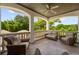 Relaxing covered patio with wicker furniture, ceiling fan, and a serene outdoor view at 2211 Azalea Pl, Winter Park, FL 32789
