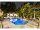 An in-ground pool with an attached spa is centered in the backyard with an outdoor bar and seating area at 2211 Azalea Pl, Winter Park, FL 32789
