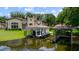 Expansive waterfront property featuring boat lifts, dock, jet skis, and luxurious main house with lush green landscaping at 2211 Azalea Pl, Winter Park, FL 32789