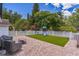 Spacious backyard with a paver patio, playset on artificial grass, and white vinyl fencing at 2604 Marble Ave, Orlando, FL 32803