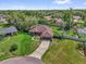 Aerial view of the home featuring a well-manicured lawn and a long driveway at 3 Pine Glen Dr, Debary, FL 32713