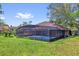 A view of the backyard highlighting the screen enclosed pool with lush landscaping at 3 Pine Glen Dr, Debary, FL 32713