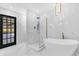 Luxurious bathroom with soaking tub, glass enclosed shower, and modern gold fixtures at 3 Pine Glen Dr, Debary, FL 32713