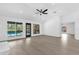 Open living room with views of the screened-in pool, a ceiling fan and wood-look flooring at 3 Pine Glen Dr, Debary, FL 32713
