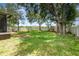 Large grassy backyard with mature trees, white fence, and playset for Gathering fun at 30308 Cheval St, Mount Dora, FL 32757