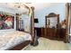 Bedroom with unique four poster bed with decorative carvings, blue painted walls and carpet, and a large dresser at 30308 Cheval St, Mount Dora, FL 32757