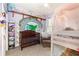 Bedroom with decor featuring a crib, toddler bed, and shelves lined with stuffed animals at 30308 Cheval St, Mount Dora, FL 32757