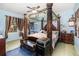 Bedroom with unique four poster bed with decorative carvings, blue painted walls and carpet, and a ceiling fan at 30308 Cheval St, Mount Dora, FL 32757
