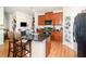 Bright kitchen boasts wood floors, granite countertops, stainless steel appliances, and a kitchen island with barstool seating at 30308 Cheval St, Mount Dora, FL 32757