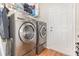 Laundry area featuring modern washer and dryer with laminate floors and access to the exterior at 30308 Cheval St, Mount Dora, FL 32757