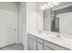 Bright bathroom featuring dual sinks, white cabinets and countertops, with a large mirror at 3142 Hill Point St, Minneola, FL 34715