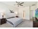 Spacious bedroom featuring a ceiling fan, a gray carpet, and an ensuite door at 3142 Hill Point St, Minneola, FL 34715