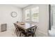 Dining area featuring a modern table, four chairs, a window for natural light and tiled floors at 3142 Hill Point St, Minneola, FL 34715