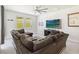 Bright living room featuring a large sectional sofa, neutral colors, and natural light from the backyard at 3142 Hill Point St, Minneola, FL 34715