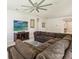 Comfortable living room featuring a large sectional sofa, entertainment center and decorative ceiling fan at 3142 Hill Point St, Minneola, FL 34715