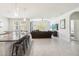 Open-concept living room features a large sofa, neutral walls, tiled floors, and backyard views at 3142 Hill Point St, Minneola, FL 34715