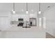 Modern white kitchen featuring stainless steel appliances, quartz countertops, and a functional island at 4572 Sw 149Th St, Ocala, FL 34473