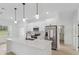 Modern white kitchen featuring stainless steel appliances, quartz countertops, and a functional island at 4572 Sw 149Th St, Ocala, FL 34473