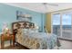Comfortable bedroom with seaside artwork, decorative pillows, and balcony access, providing a cozy retreat at 4631 S Atlantic Ave # 8102, Port Orange, FL 32127