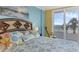Bedroom close-up, featuring beach-themed bedding, decorative pillows, and a relaxing rocker, inviting comfort at 4631 S Atlantic Ave # 8102, Port Orange, FL 32127