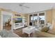 Spacious living room featuring wood-look floors, ceiling fan, and sliding glass doors to patio at 4631 S Atlantic Ave # 8102, Port Orange, FL 32127