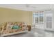Bright living room with yellow walls, tile floor, and comfortable futon near the window at 4631 S Atlantic Ave # 8102, Port Orange, FL 32127