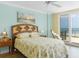 Comfortable main bedroom with a ceiling fan, sliding door, ocean view and wooden floors at 4631 S Atlantic Ave # 8102, Port Orange, FL 32127