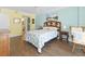 Comfortable bedroom features wood floors, coastal decor and a view into the en-suite bathroom at 4631 S Atlantic Ave # 8102, Port Orange, FL 32127