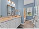 Bright bathroom with blue walls, a white vanity, and a shower-tub combination at 5005 Shore Side Dr, Lakeland, FL 33812