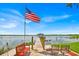 Scenic lake view showcasing a private dock with seating and American flag, perfect for relaxing by the water at 5005 Shore Side Dr, Lakeland, FL 33812