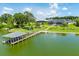 Aerial view of lakefront home with private dock, boat lift, American flag, and a spacious yard perfect for entertaining at 5005 Shore Side Dr, Lakeland, FL 33812