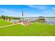 Lakefront property view with a private dock, covered seating, and lush green lawn leading to the water's edge at 5005 Shore Side Dr, Lakeland, FL 33812